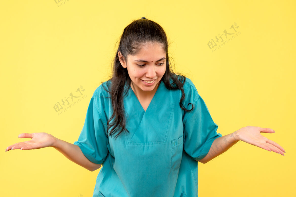 护士前视图微笑着身着制服的女医生在黄色孤立的背景上张开双手前面医生女医生