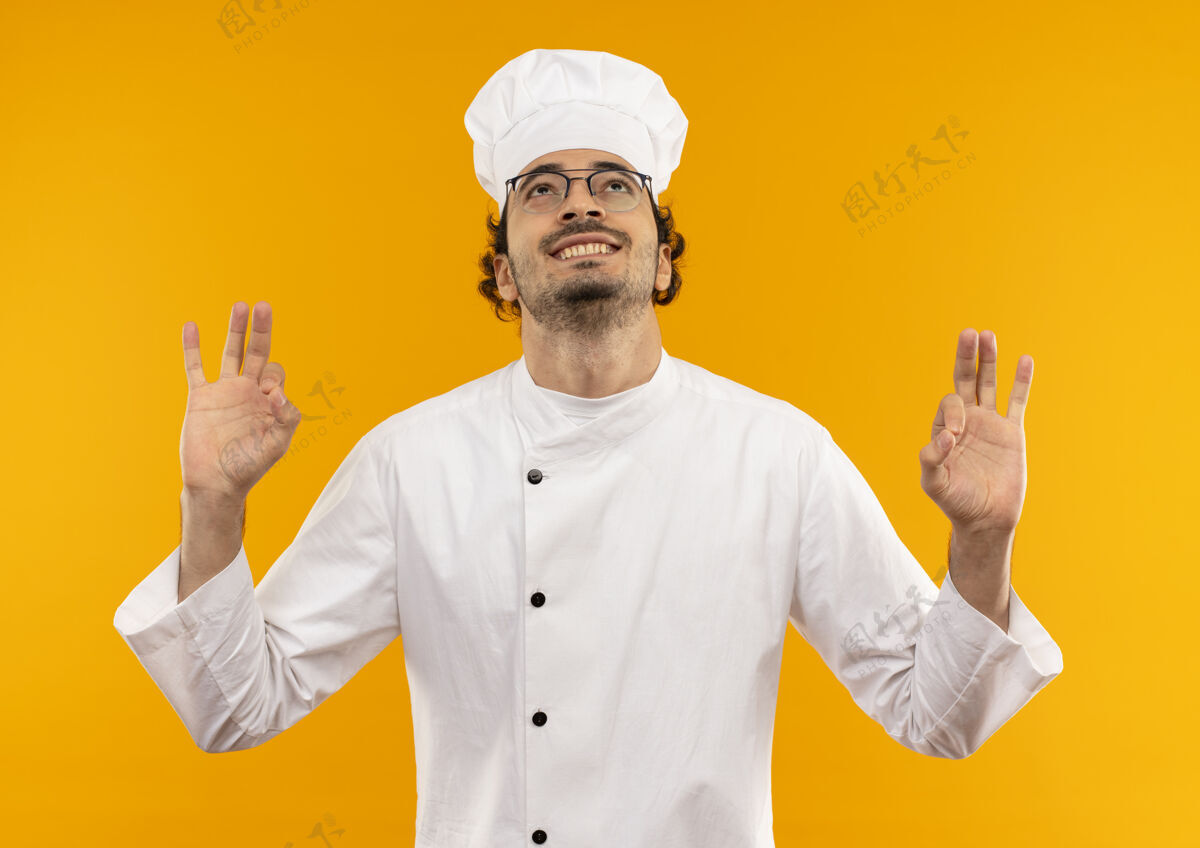 制服看着微笑着的年轻男厨师 穿着厨师制服 戴着眼镜 摆出一副很好的姿势男人好的黄色