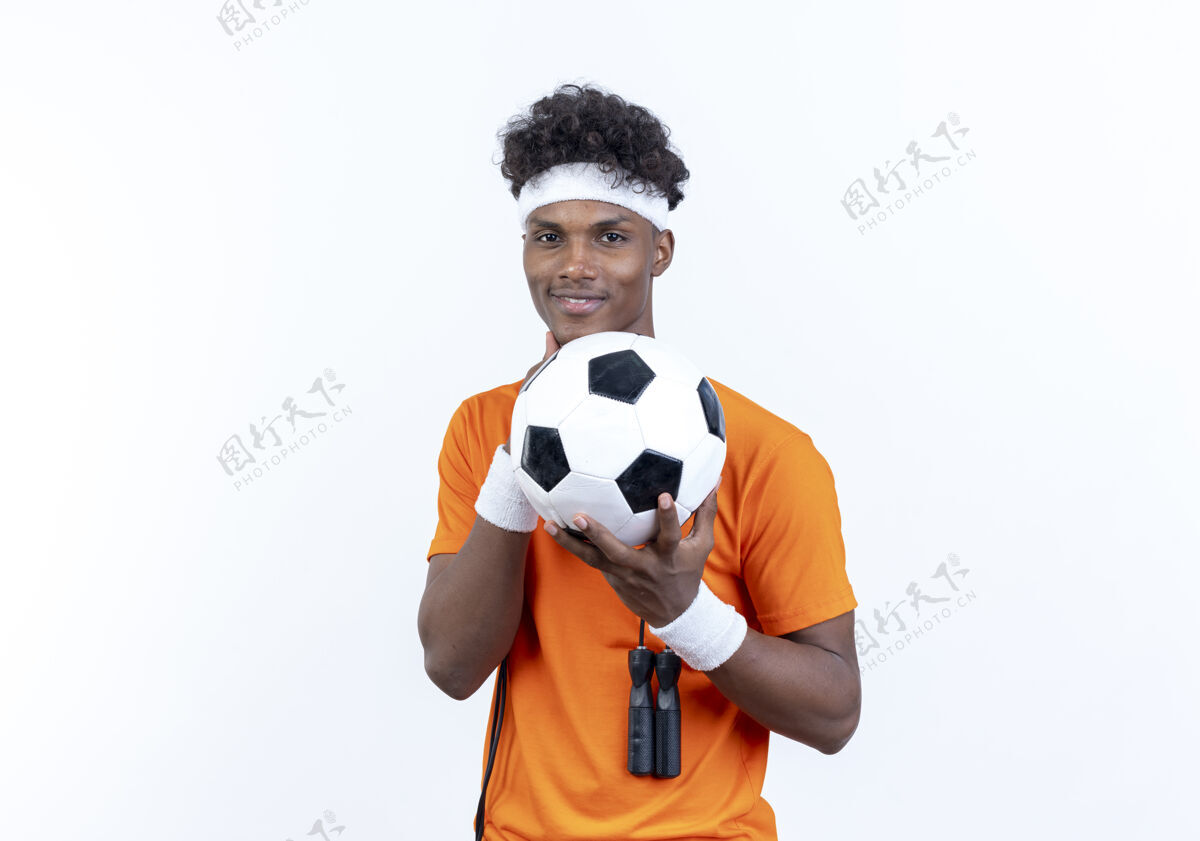 头带很高兴年轻的美国黑人运动男子戴头带和手环举行与跳绳在肩上的球非裔美国人足球足球