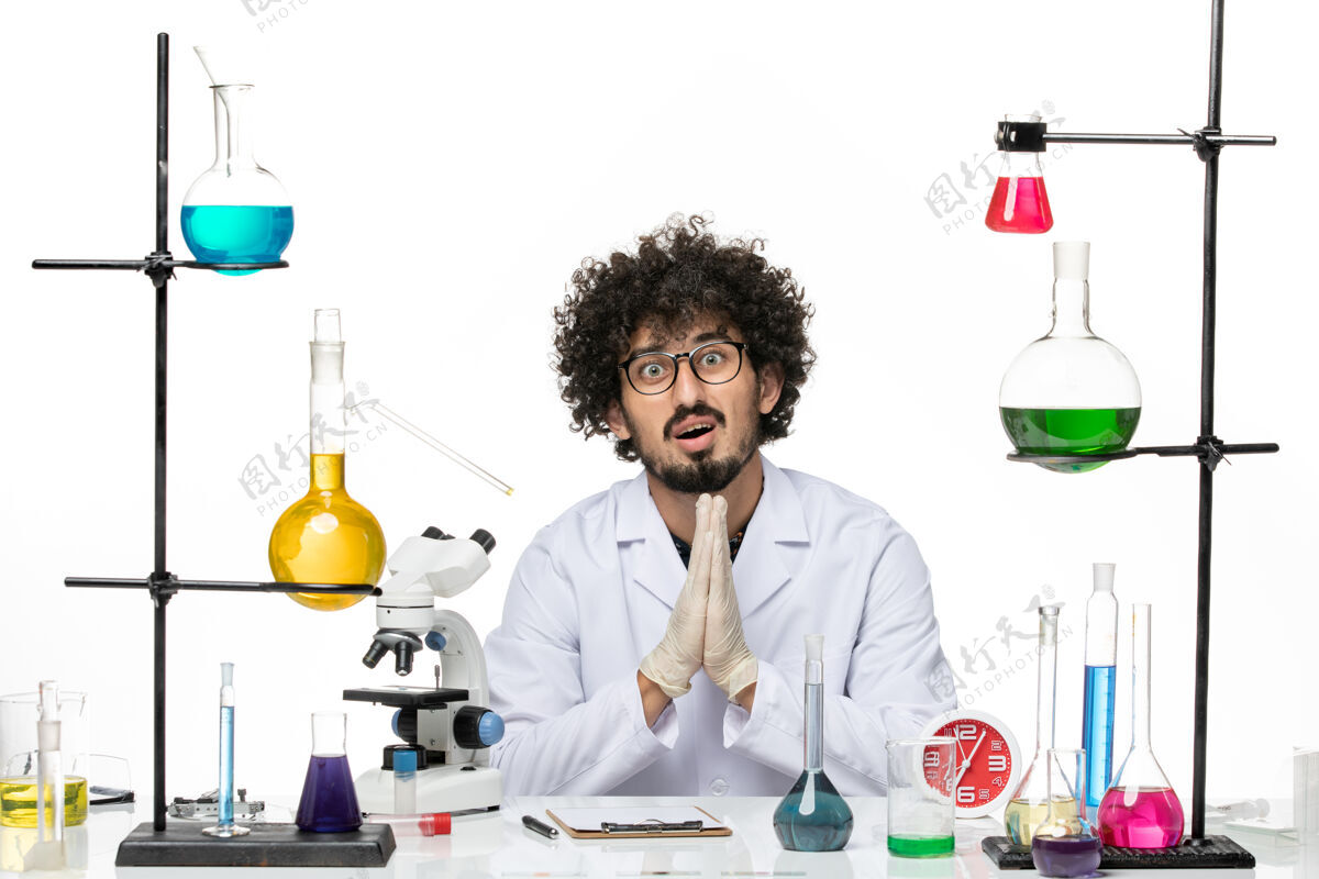 前面正面图身着医疗服的男性化学家在白色空间摆姿势祈祷男化学家病毒医生