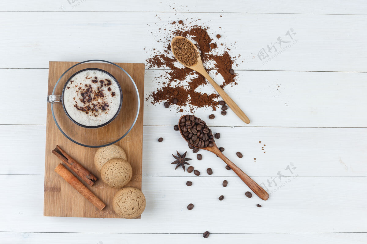 豆类一些咖啡与磨碎的咖啡 咖啡豆 肉桂棒 饼干在一个木杯和砧板背景 平放新鲜的咖啡因摩卡咖啡