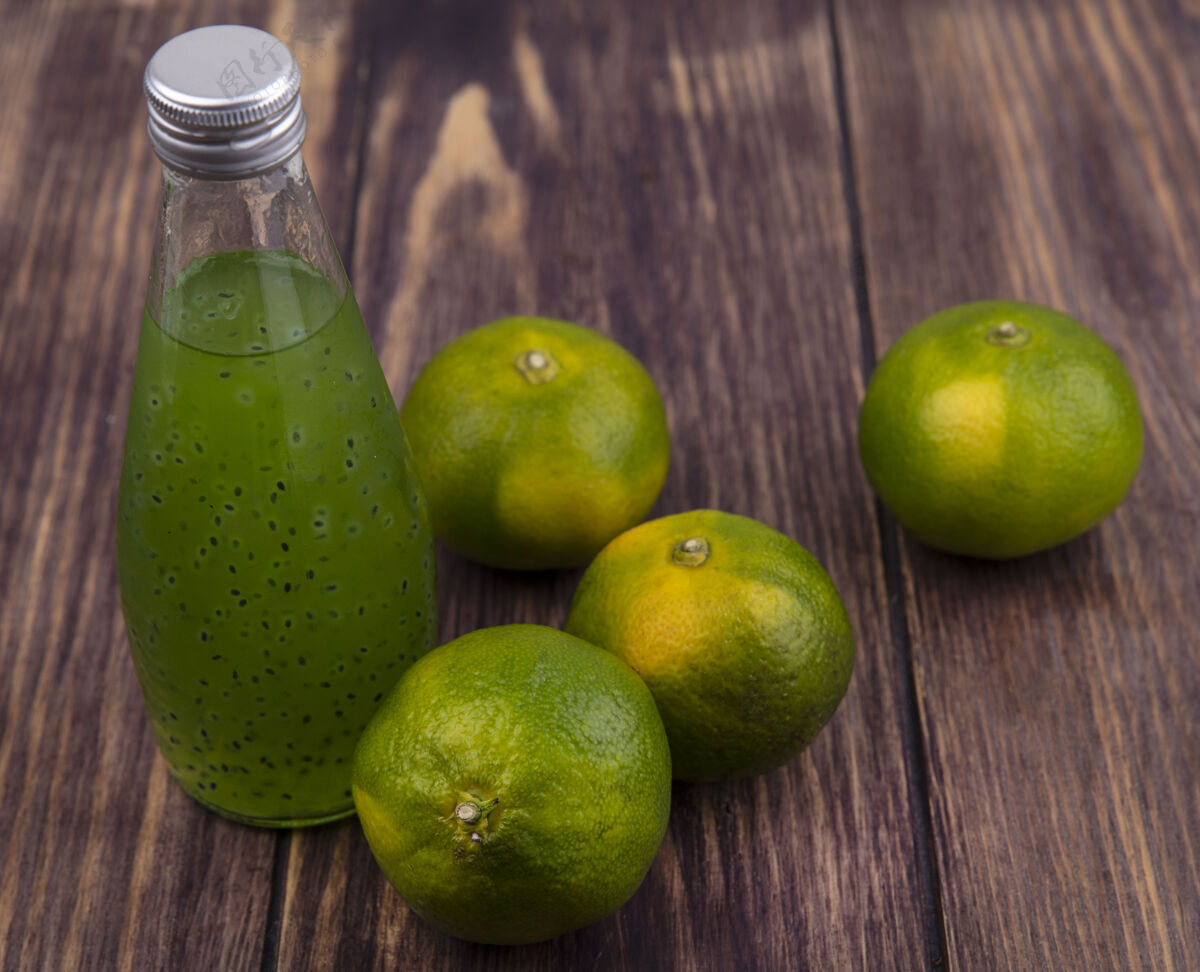 瓶子木墙上绿色橘子汁瓶侧视图果汁风景木头