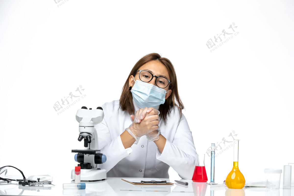 病毒正面图：女医生穿着白色医疗服 戴着面罩 因为科维德坐在浅白的空间里浅白色西装医院