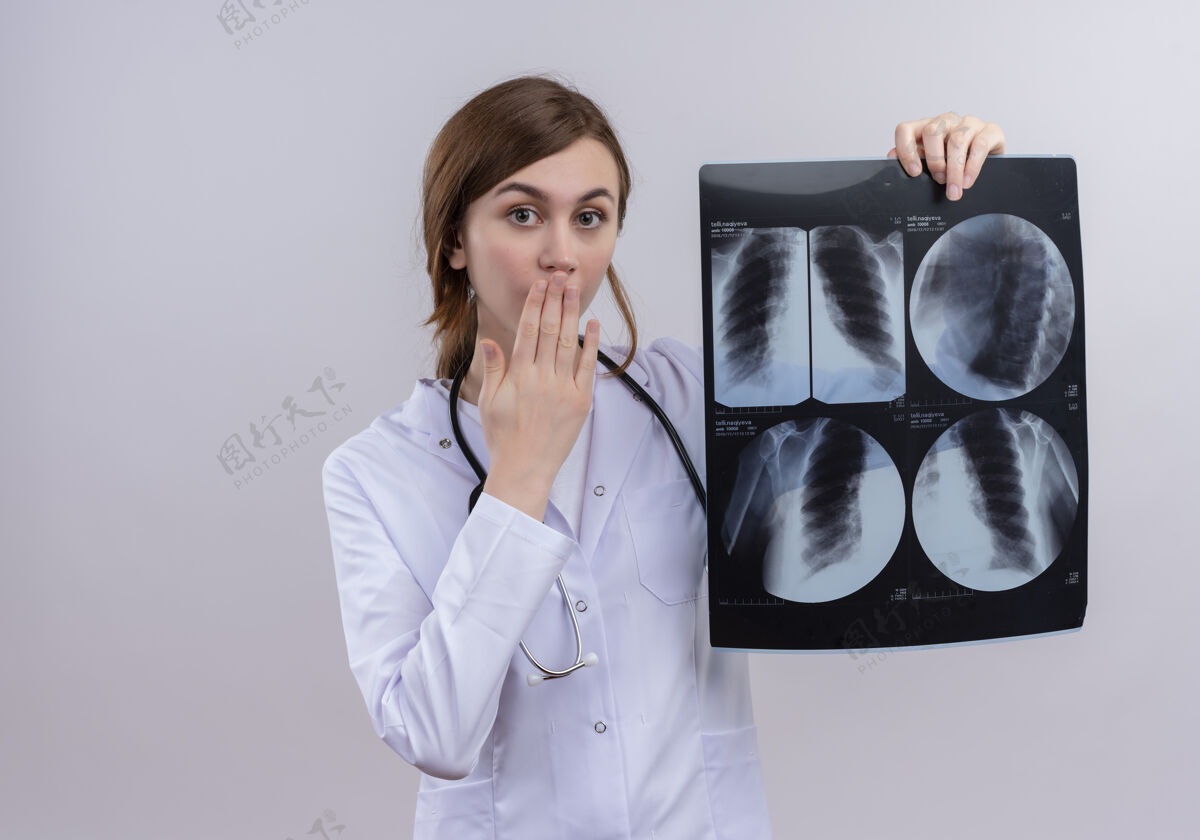 女年轻的女医生穿着医用长袍 戴着听诊器 拿着x光片 站在隔离的白墙上 留着复印空间长袍穿年轻