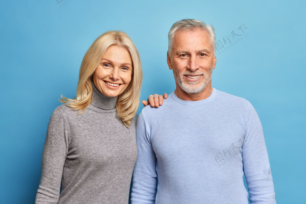 年龄快乐的老年男女表达积极的情感一起摆出爱的姿势隔着蓝色的墙婚礼人老年人