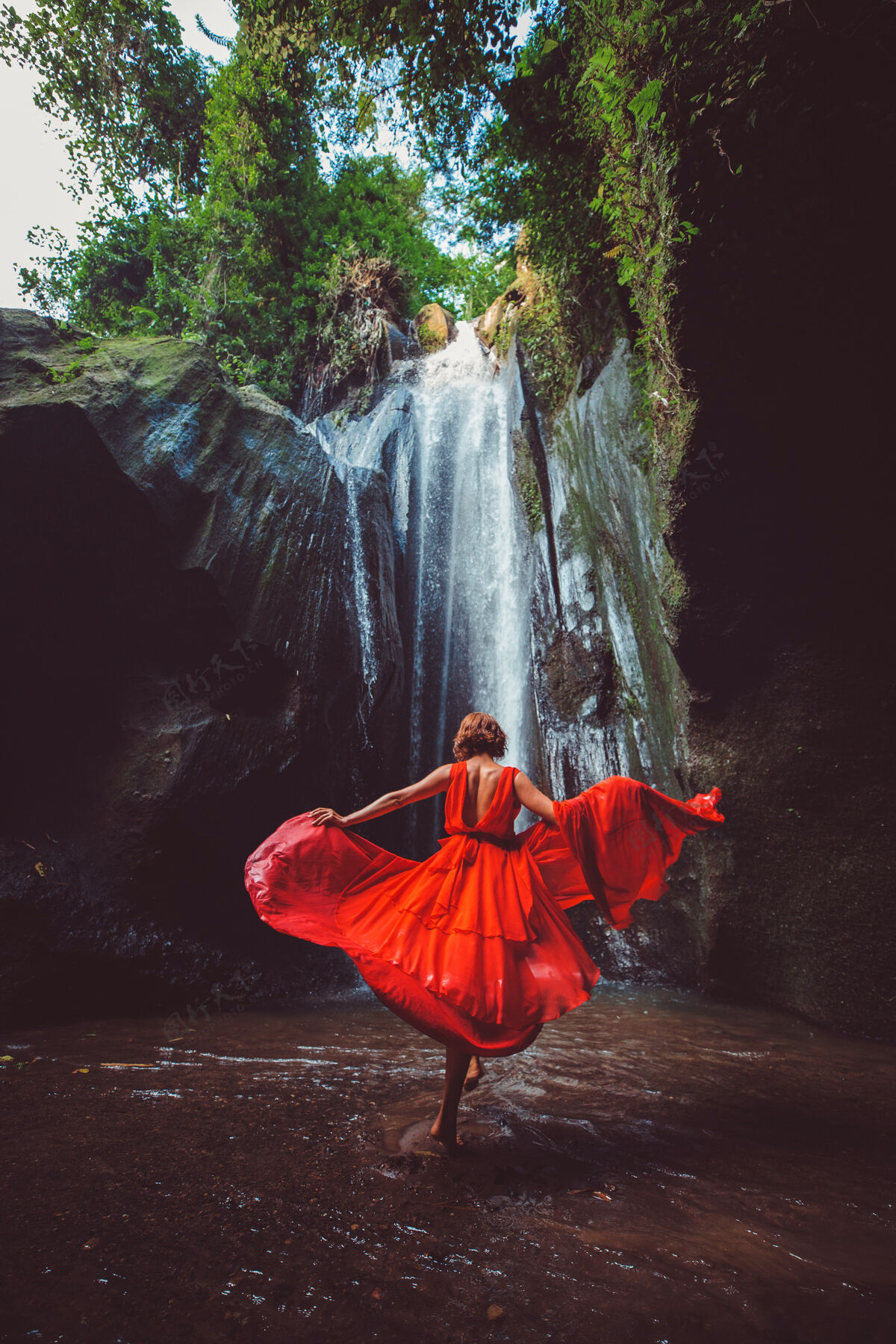 摇滚穿红裙子的女孩在瀑布里跳舞自然金发魅力