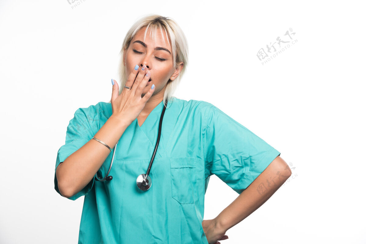 医院带听诊器的女医生在白色的表面感到困倦女士工作听诊器