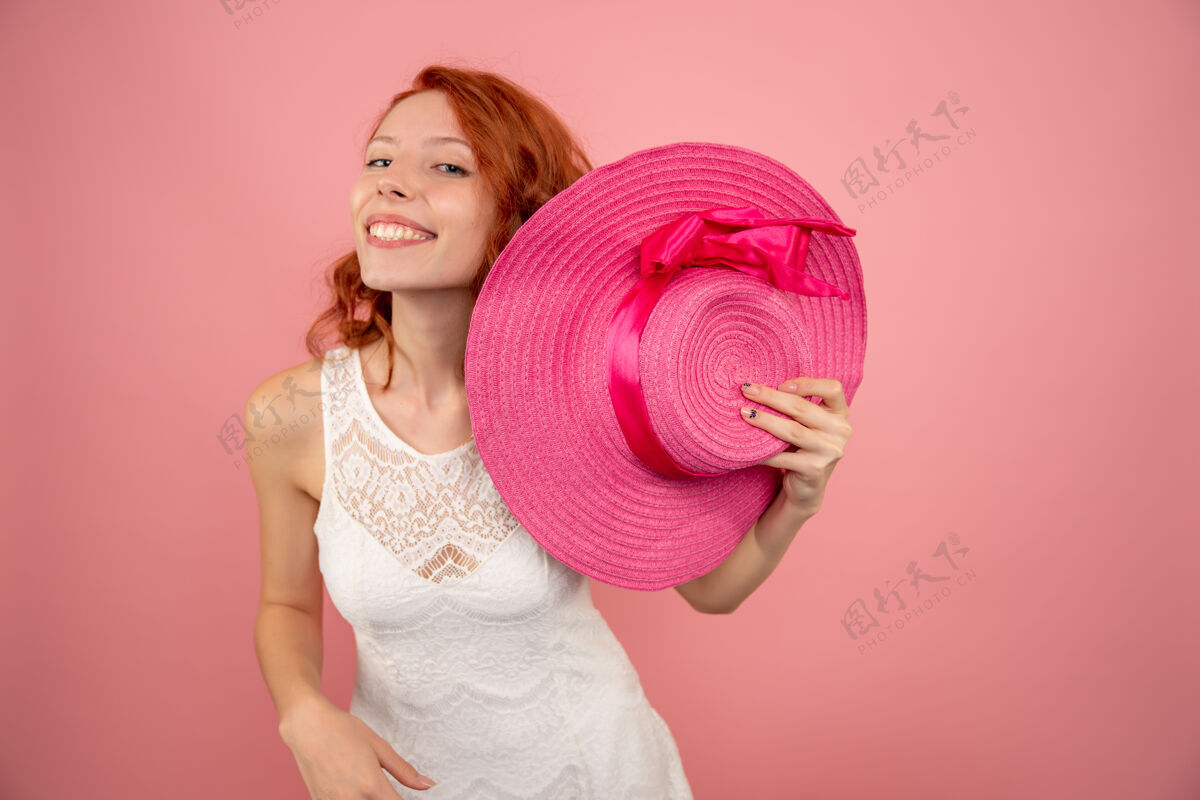 成人年轻女性在粉色墙上微笑的正面图病毒微笑头发