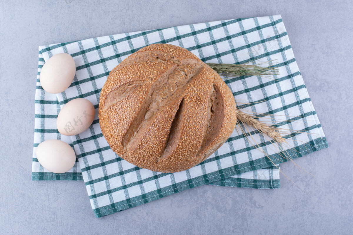 面粉麦秆鸡蛋和面包面包放在折叠毛巾大理石表面毛巾鸡蛋小麦