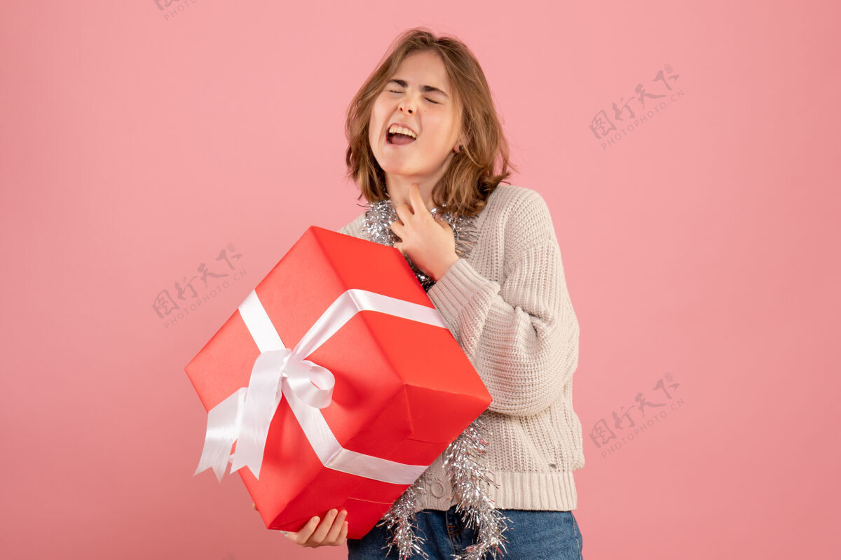 礼物手持圣诞礼物的年轻女性持有粉色情感