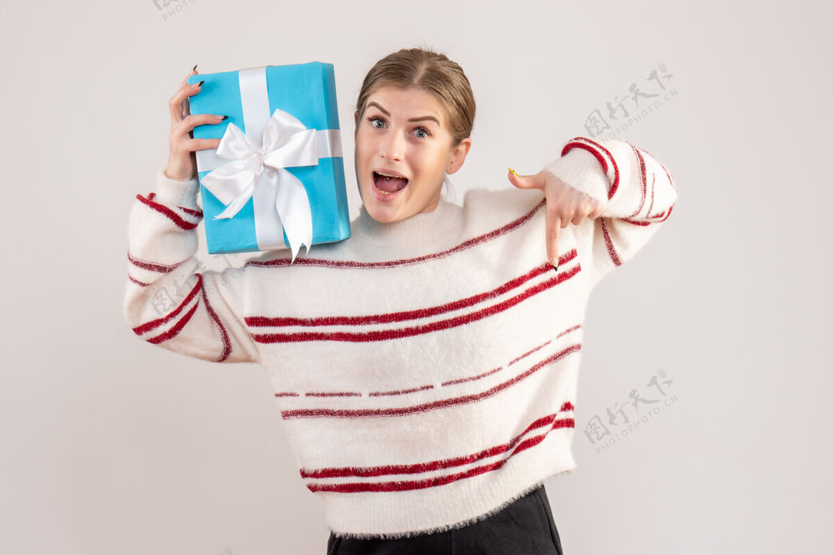 人拿着白色礼物的年轻女性圣诞节礼物年轻女性