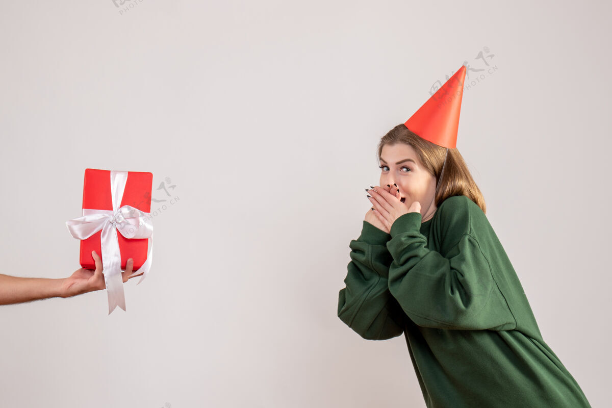 圣诞节年轻的女性接受来自白人男性的礼物男性帽子风景