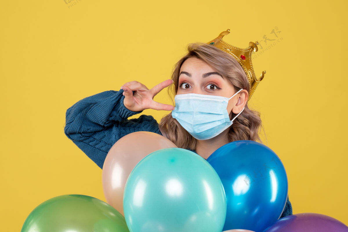 星球年轻的女性拿着黄色的无菌面具气球球圣诞节消毒