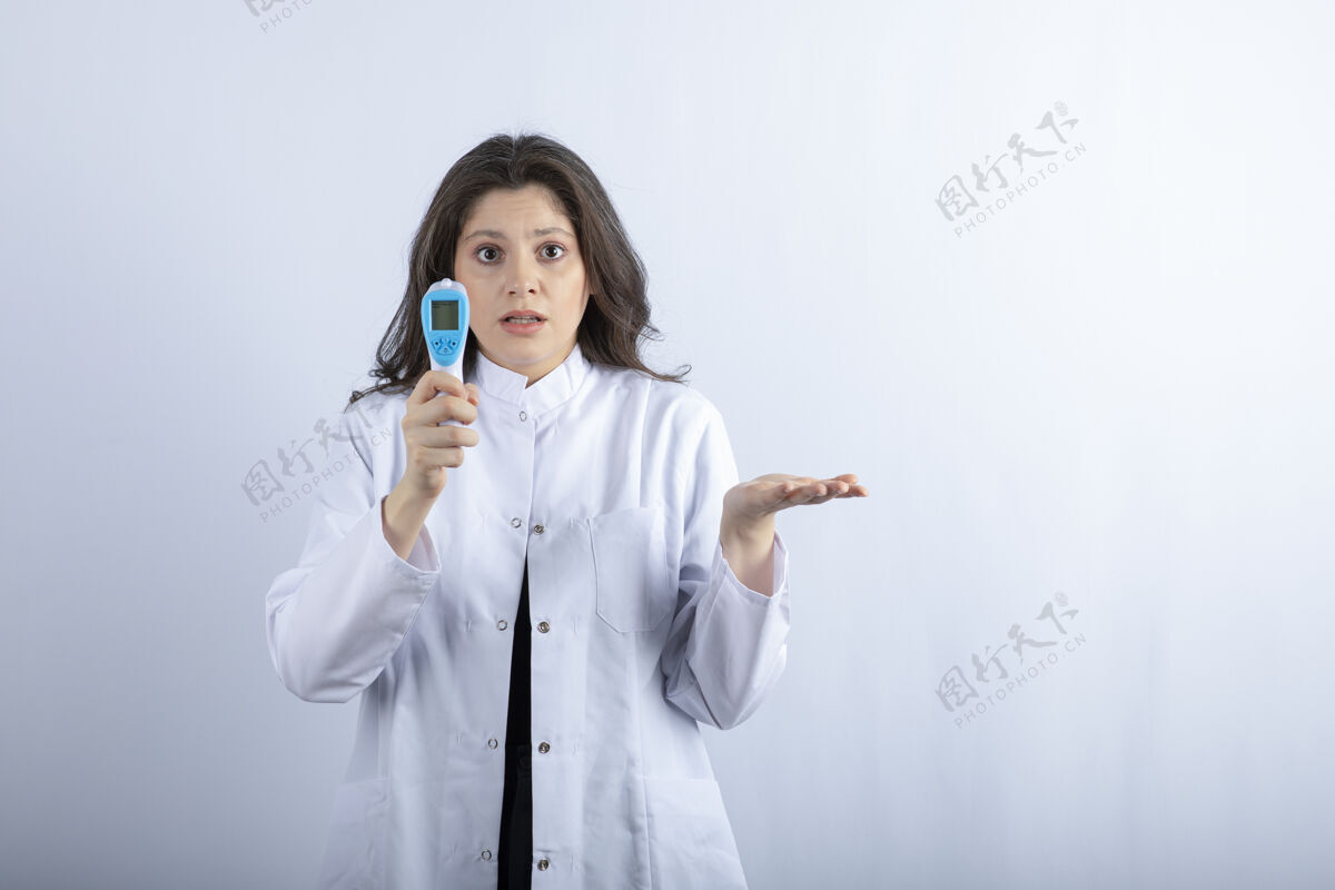温度计女医生拿着温度计站在白墙上保健护士助理