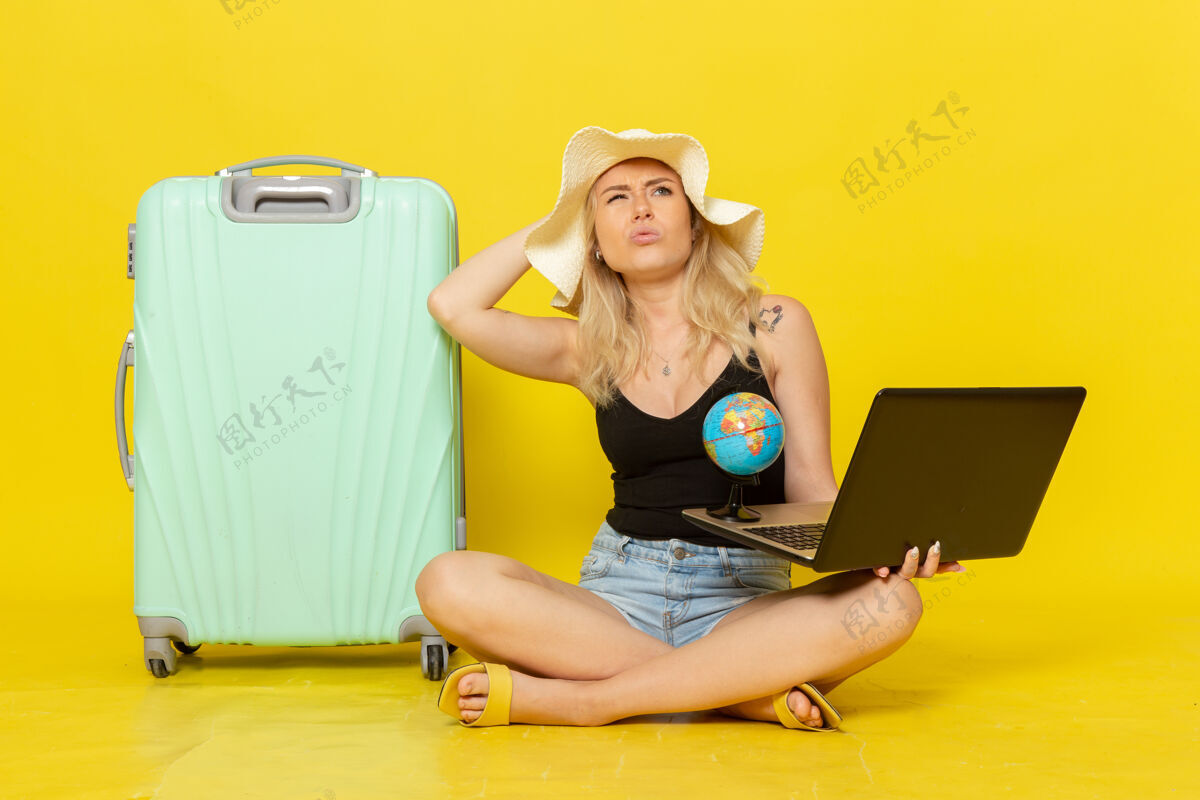 航行前视图年轻女性拿着她的笔记本电脑和地球仪地球仪前面人
