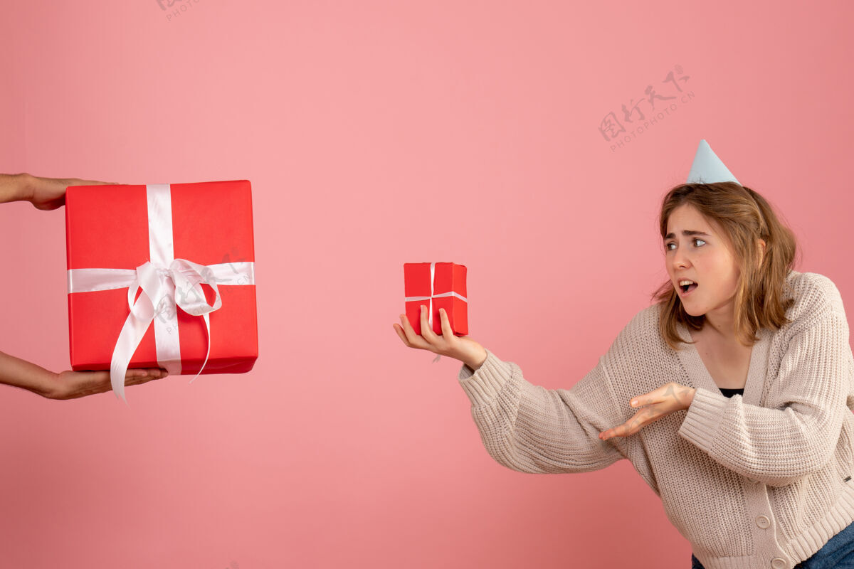 购物者年轻的女性拿着圣诞礼物 接受粉色的男性礼物粉红色礼物年轻的女性