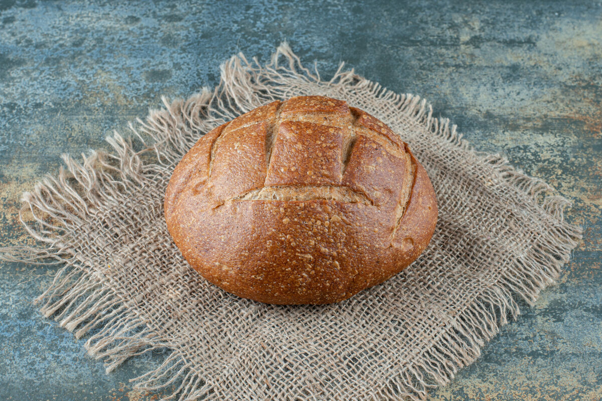 小面包一个全新的棕色面包放在麻布上麻布粗麻布面包房