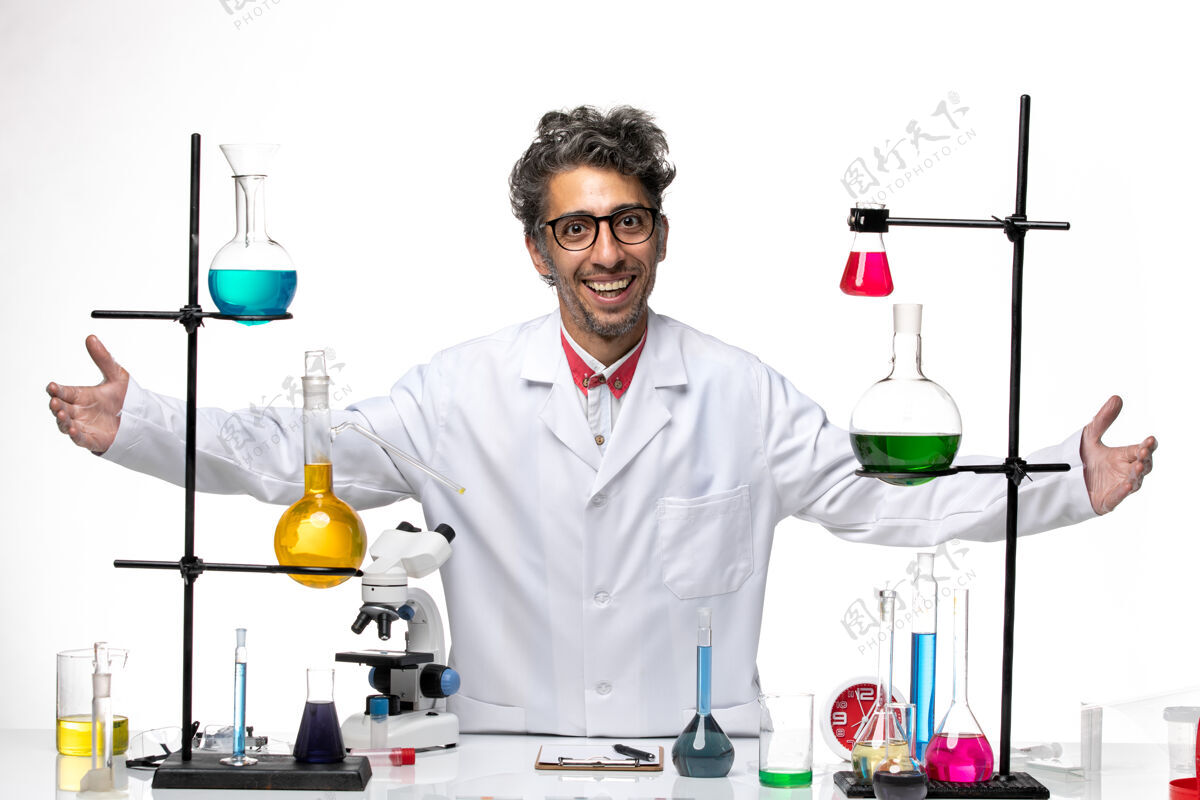 解决方案正面图：男科学家在用解决方案和微笑工作医生男性化学