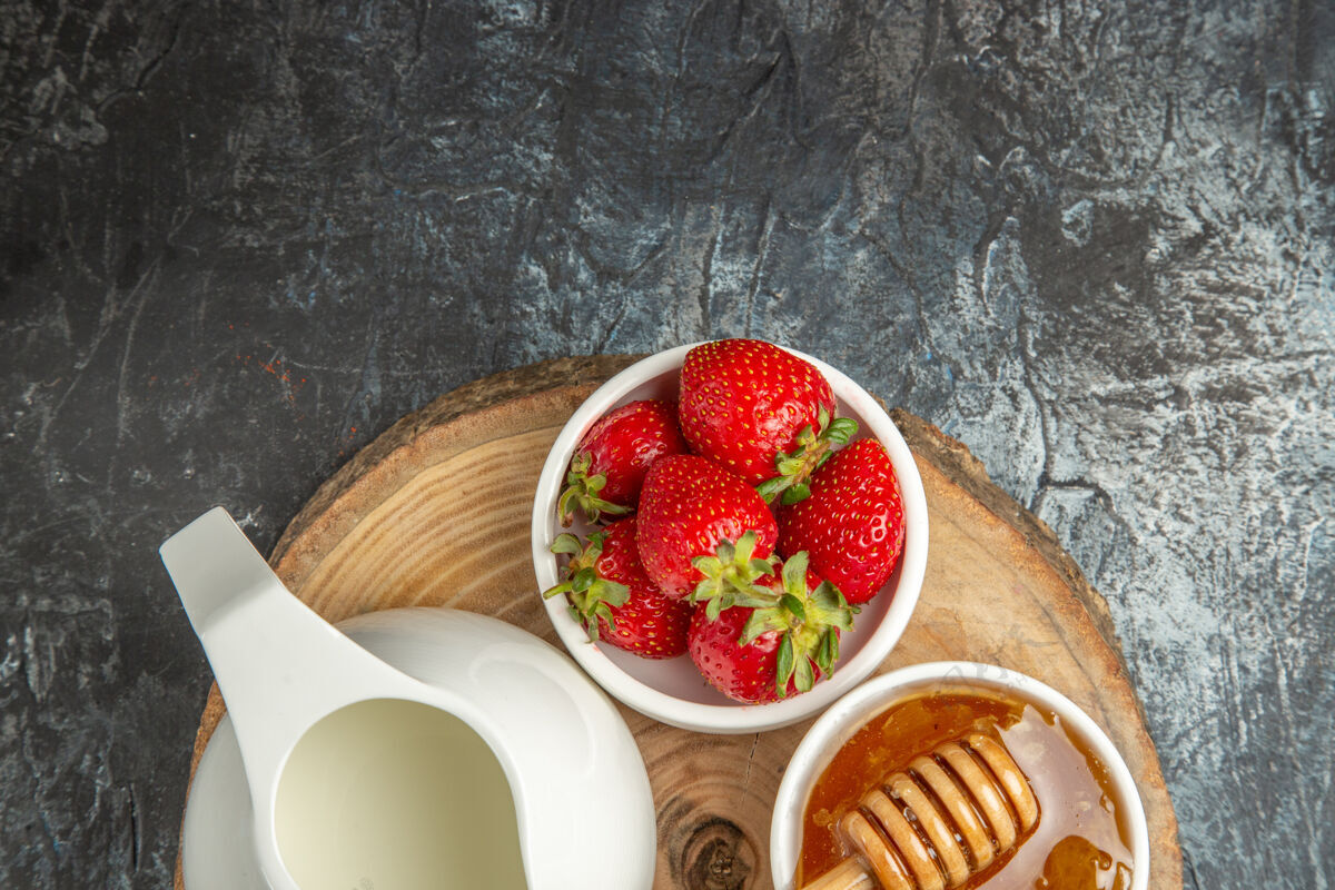 草莓顶视图新鲜草莓加蜂蜜和面包在黑暗的表面食物水果甜果冻面包甜点果冻