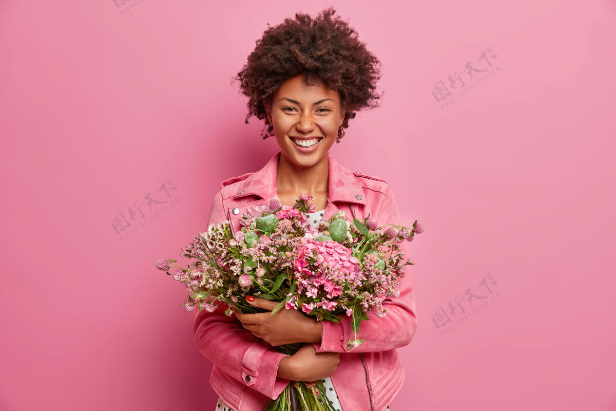 请美丽的非洲裔美国女人表达真挚的情感 拥抱花束 有春天的心情芳香花模特