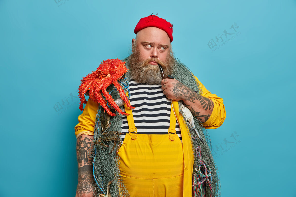 生物体贴的男人形象有海洋职业 愁眉苦脸地抽烟斗 拿着渔具摆姿势 背着章鱼 想着下一次的航海或探险丰满帽子人类