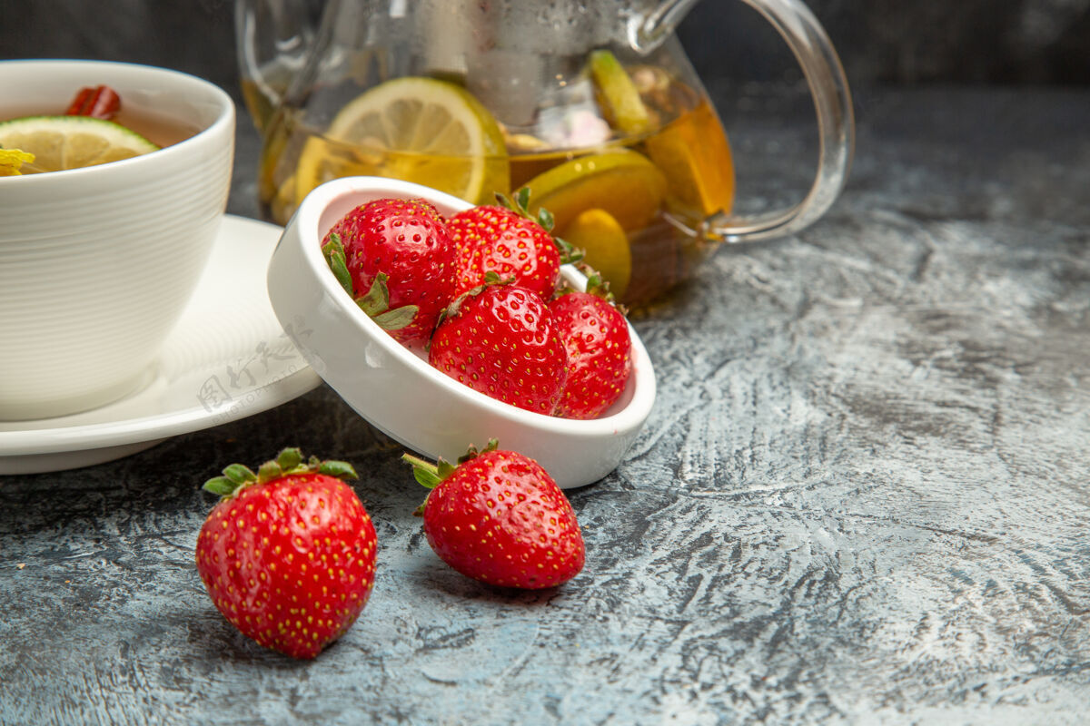 茶杯正面是一杯带有草莓的茶 表面是深色的水果茶浆果新鲜水果甜点