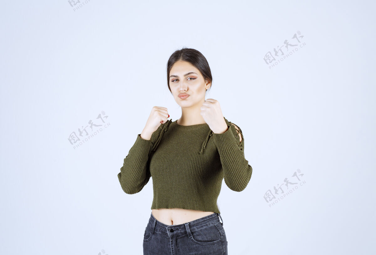 女士一个穿着绿色衣服的年轻可爱的女模特展示如何打拳站立年轻人女性