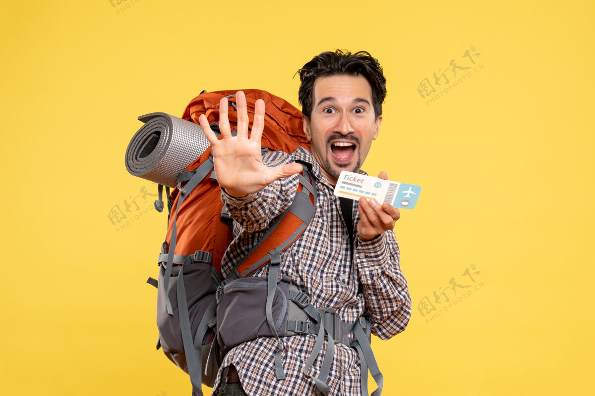 航空正面图年轻男子背着背包拿着黄色的车票成人举行校园