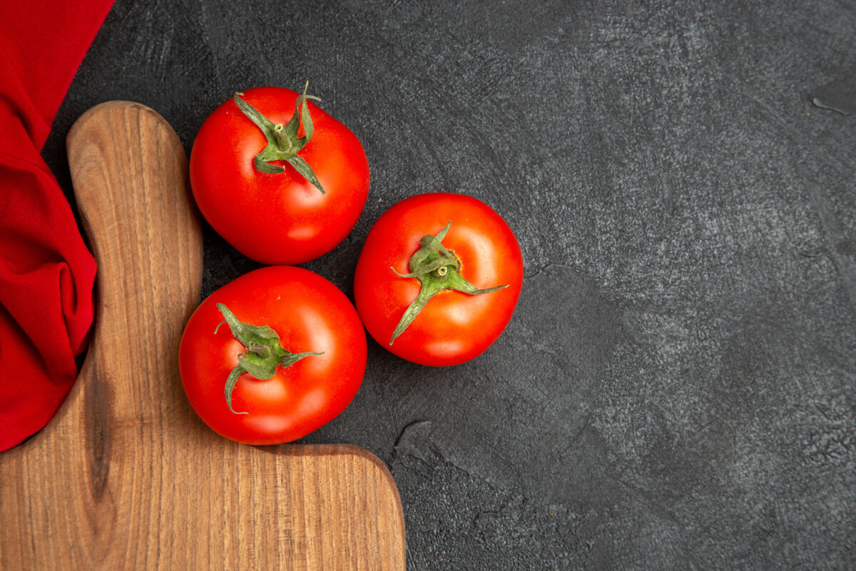 红色顶近看红色西红柿红色毛巾和一个砧板在黑暗的地面与复制空间牛排番茄成熟深色