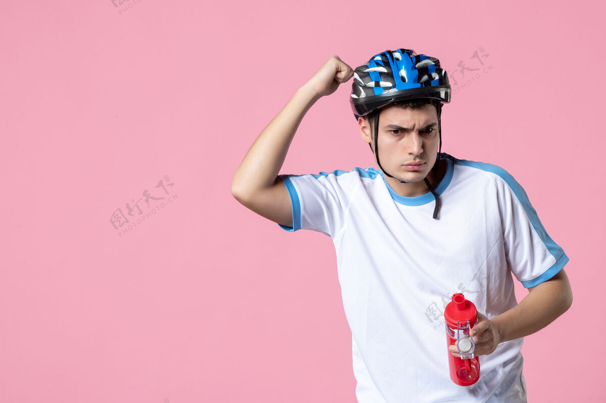 年轻前视图穿着运动服 戴着头盔 拿着一瓶水的年轻运动员速度锻炼前面
