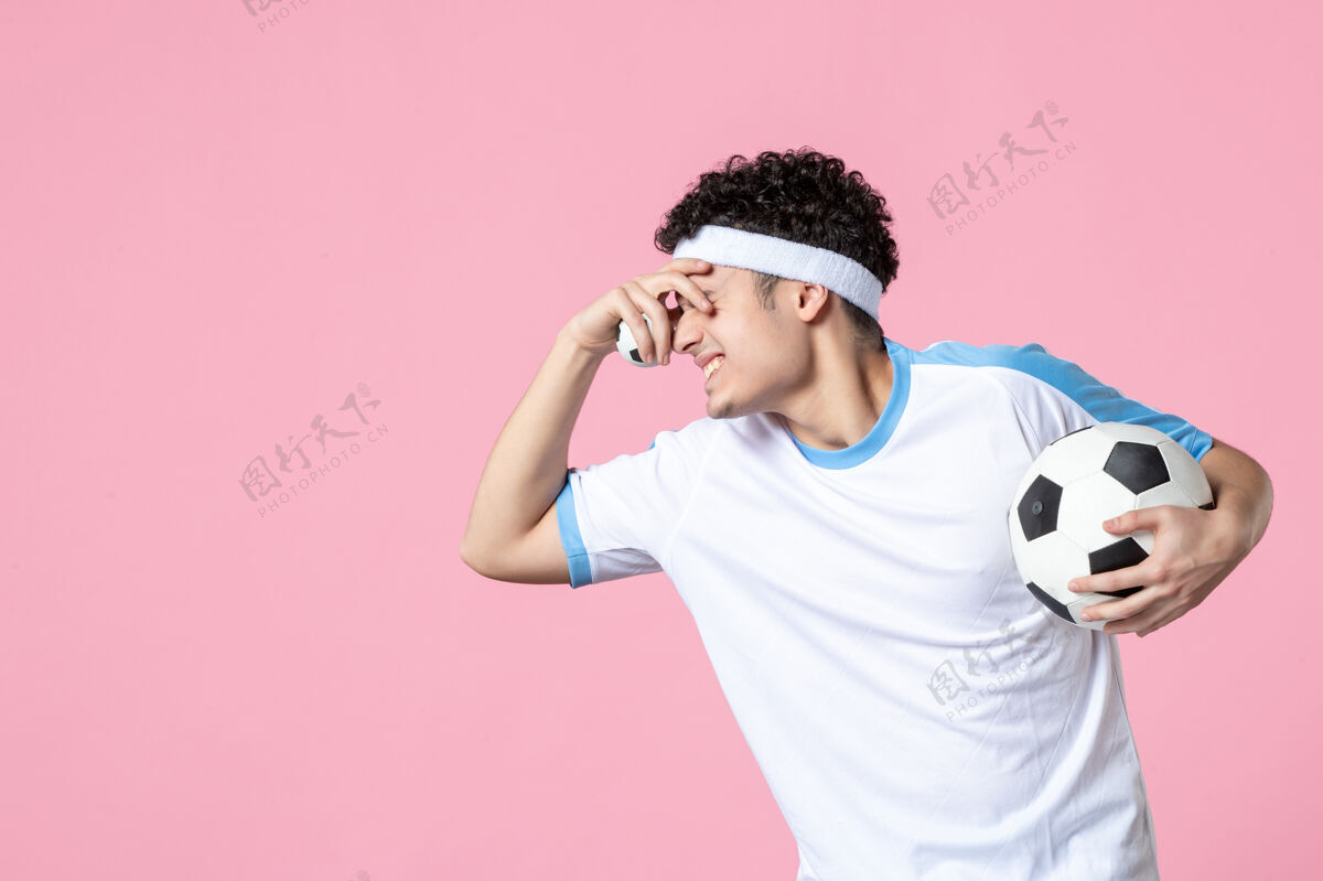 投球前视图穿着运动服的足球运动员拿着球前面运动球