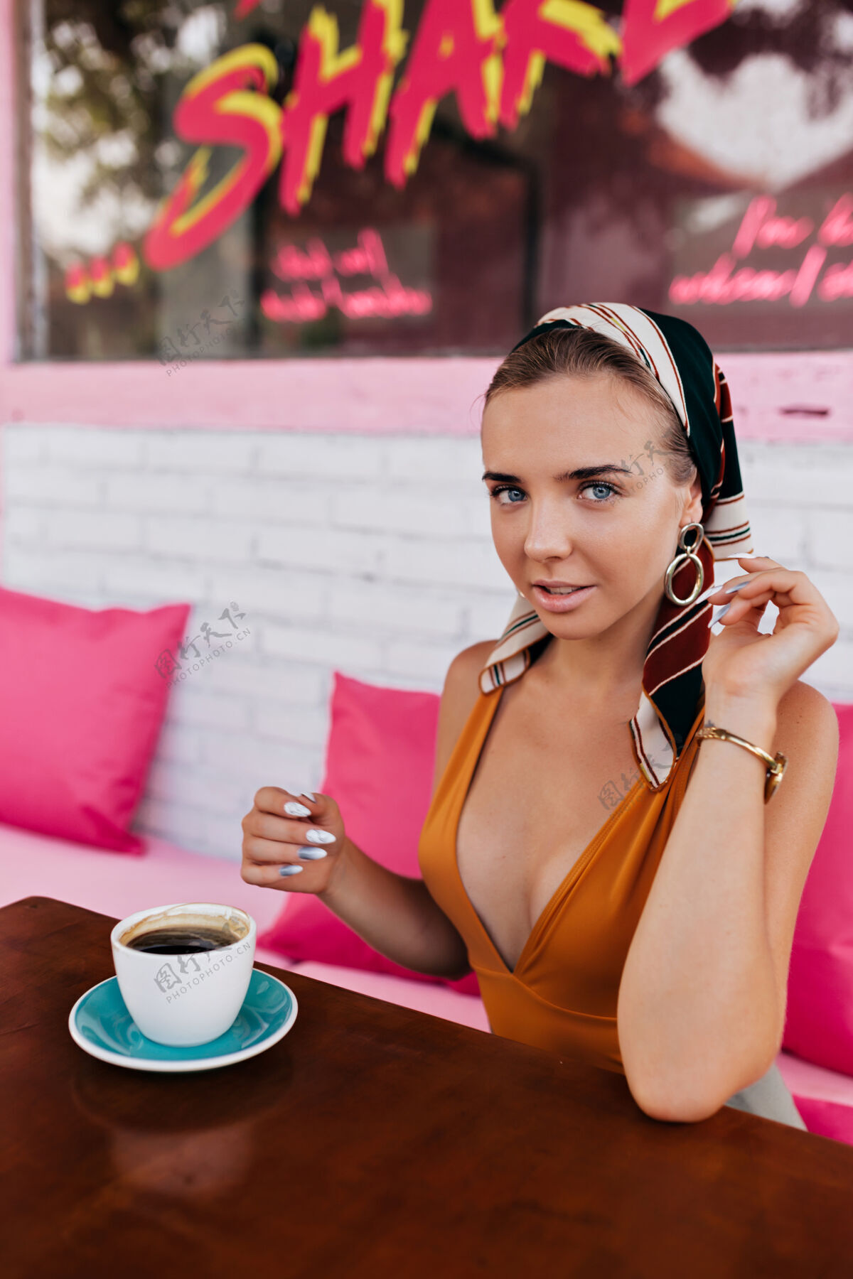 和谐快乐的金发女模特的特写肖像戴着珠宝和头饰在外面喝咖啡华丽装束活力