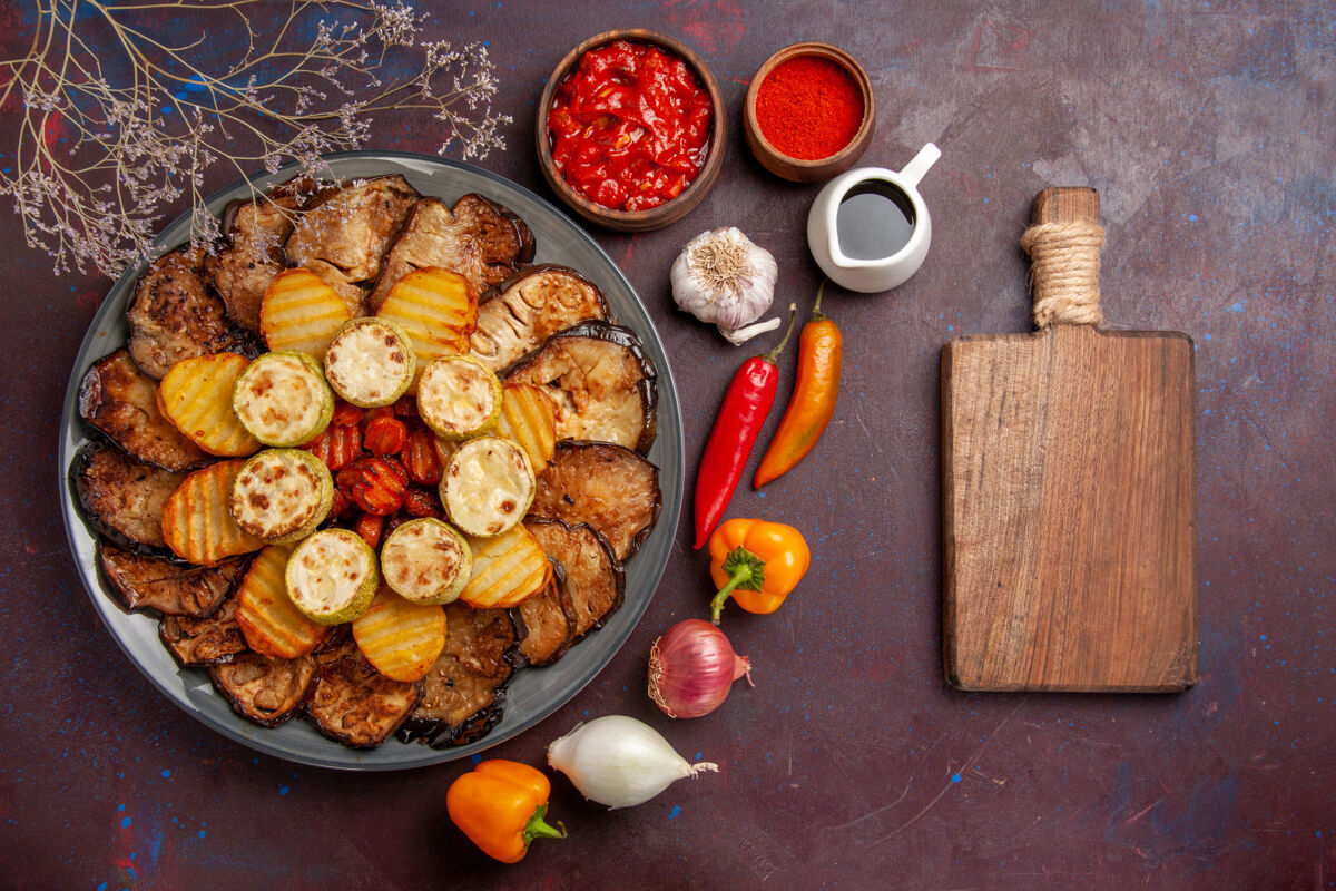 美味俯瞰美味的烤蔬菜土豆和茄子在黑暗的背景下烤箱烹饪烤蔬菜烘焙顶部土豆
