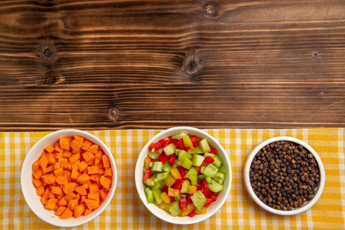 生的顶视图棕色木桌上的甜椒切片和调味料蔬菜餐食品健康沙拉托盘木材美味