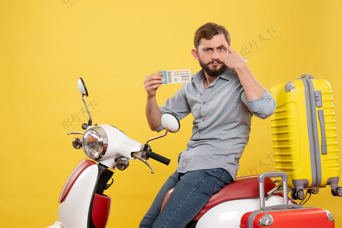 输送机旅游概念的正面图 一个思维古怪的年轻人坐在摩托车上 背着手提箱 手里拿着黄色的车票奇迹旅游人
