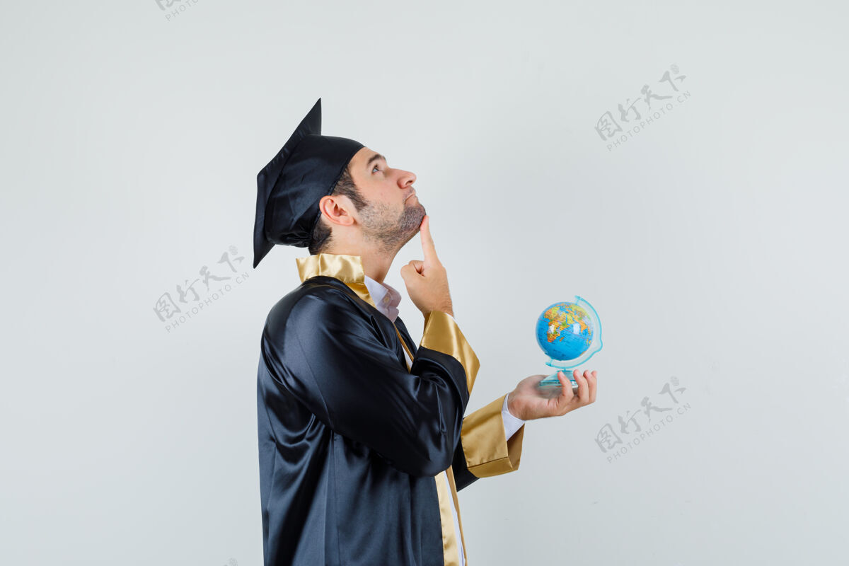 学校年轻人拿着毕业制服的地球仪 神情沉思胡须年轻男人