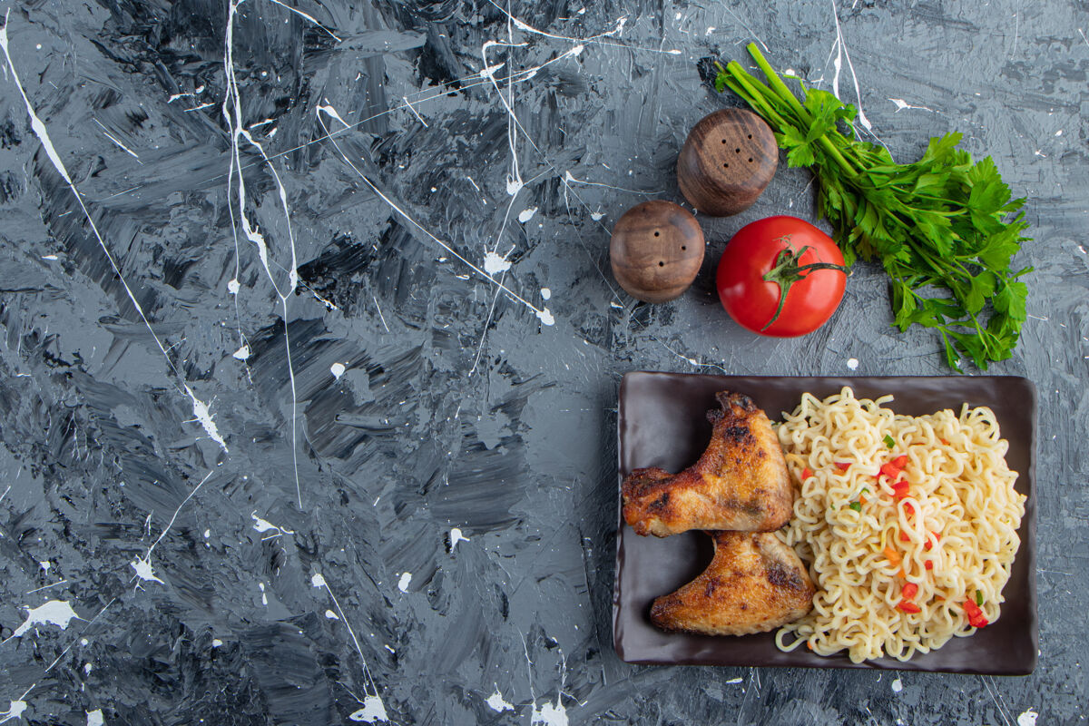 烹饪把鸡翅和面条放在蔬菜旁边的盘子里 放在大理石背景上美味美食亚洲菜