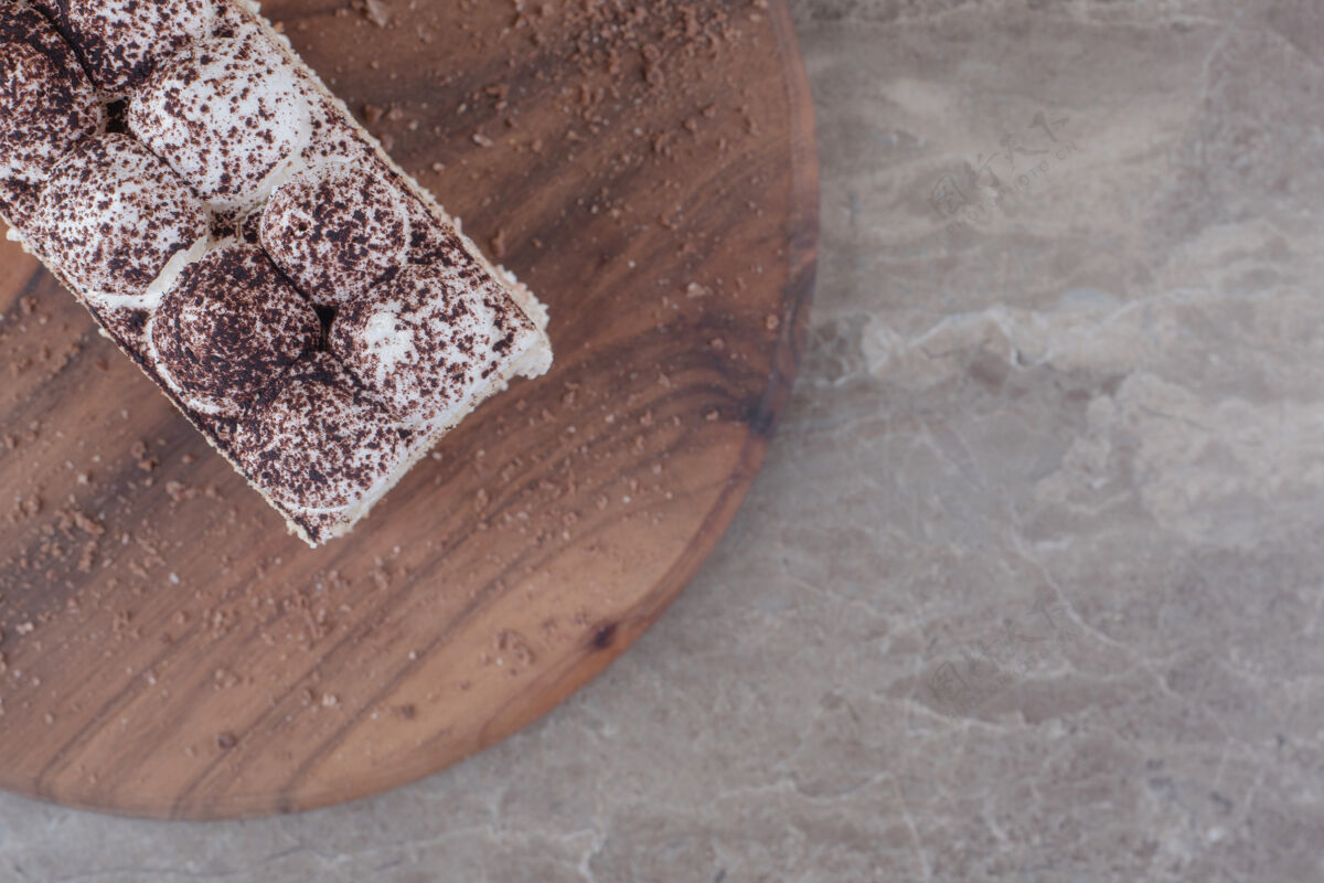 粉奶油和可可粉覆盖在大理石板上的蛋糕片上口感烘焙美味