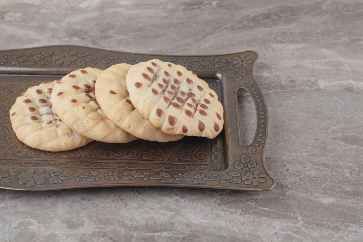 曲奇脆饼干放在大理石上华丽的托盘上烘焙甜点托盘