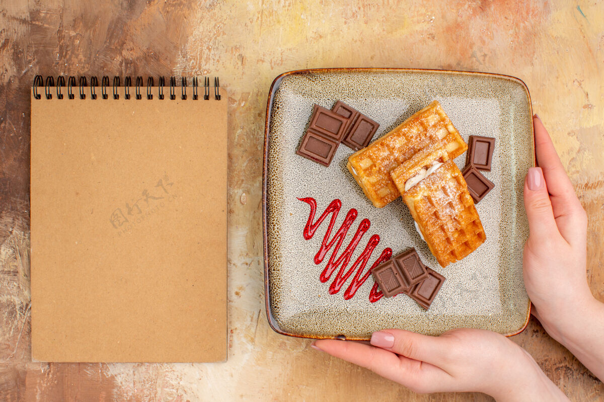 饼干俯瞰美味的华夫饼与巧克力条在棕色的背景巧克力甜点容器