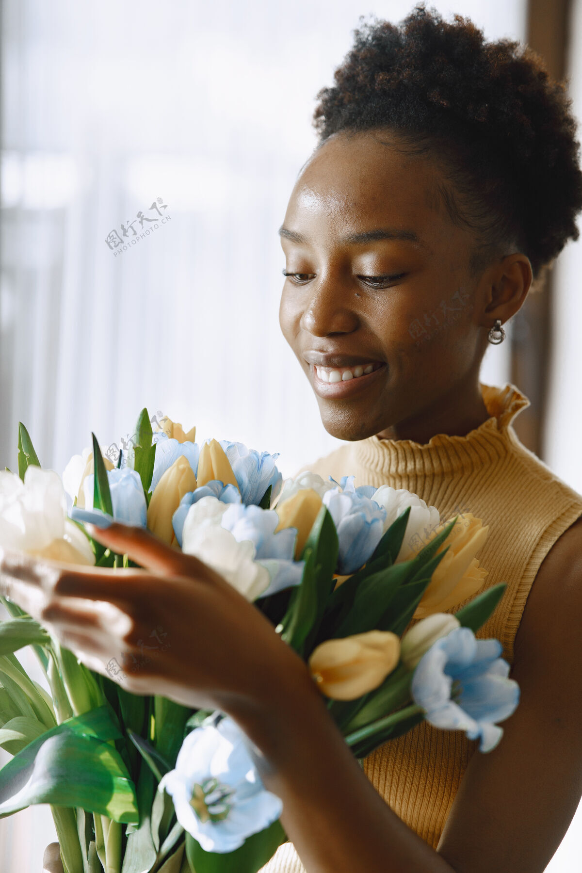 Alstroemeria开着花的非洲女孩手里拿着一束郁金香窗边的女人年轻积极女人