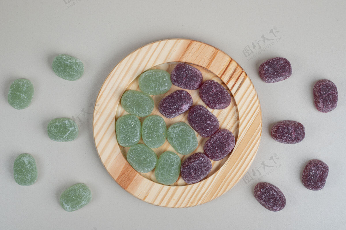 什锦绿色和紫色的果冻糖果放在木盘上美味邦邦糖果
