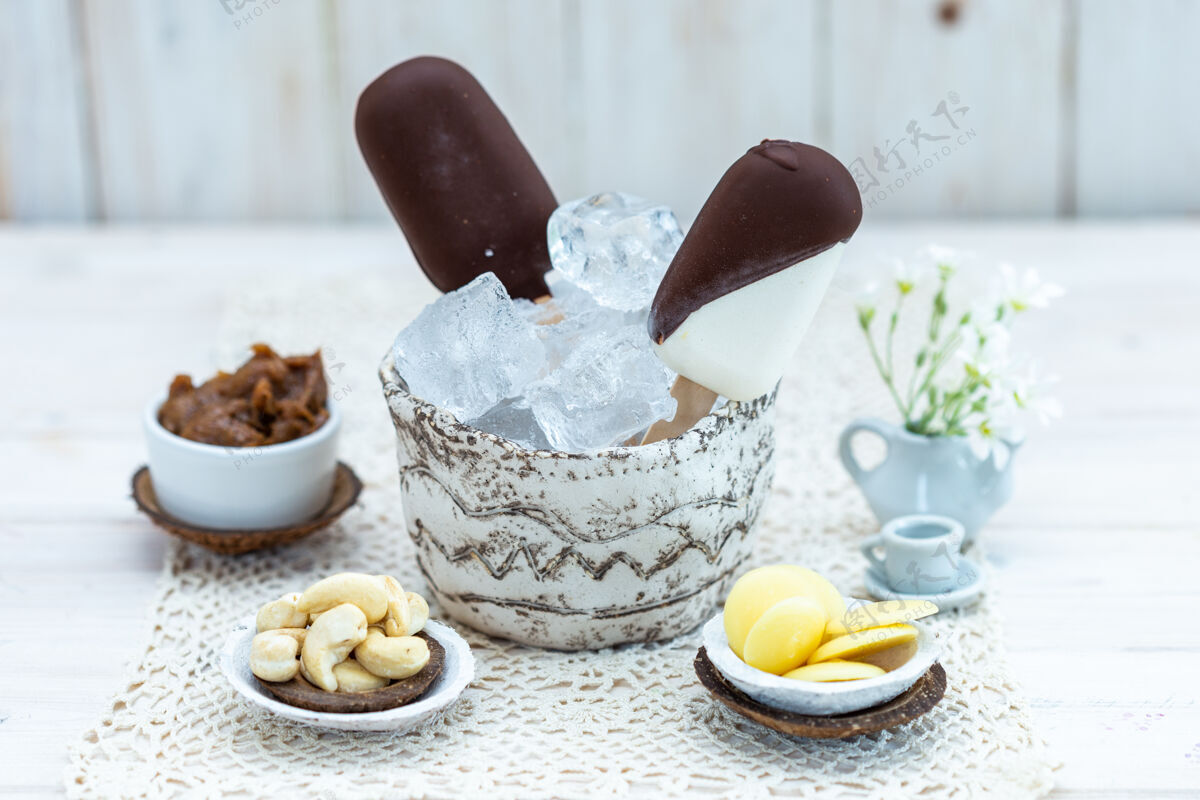 棒特写镜头素食冰淇淋棒在一个碗与冰块在一张桌子上与其他零食冰淇淋冷的樱桃