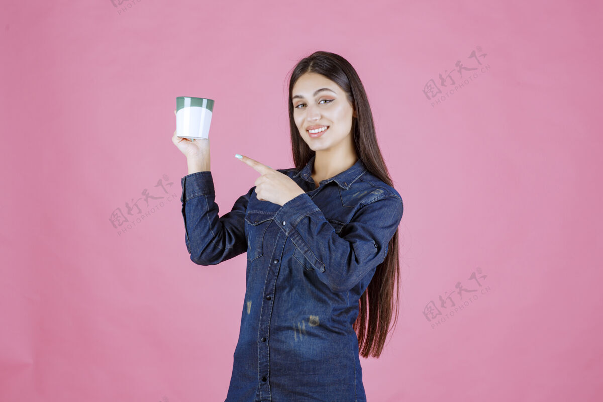 女性拿着咖啡杯指着它的年轻女人美食姿势人类