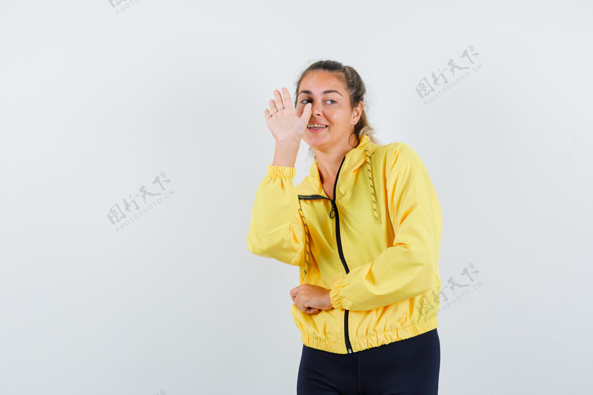 成人一个金发女人伸出手 和一个穿着黄色棒球服和黑色裤子的人打招呼 看上去很和蔼可亲前面干净自然