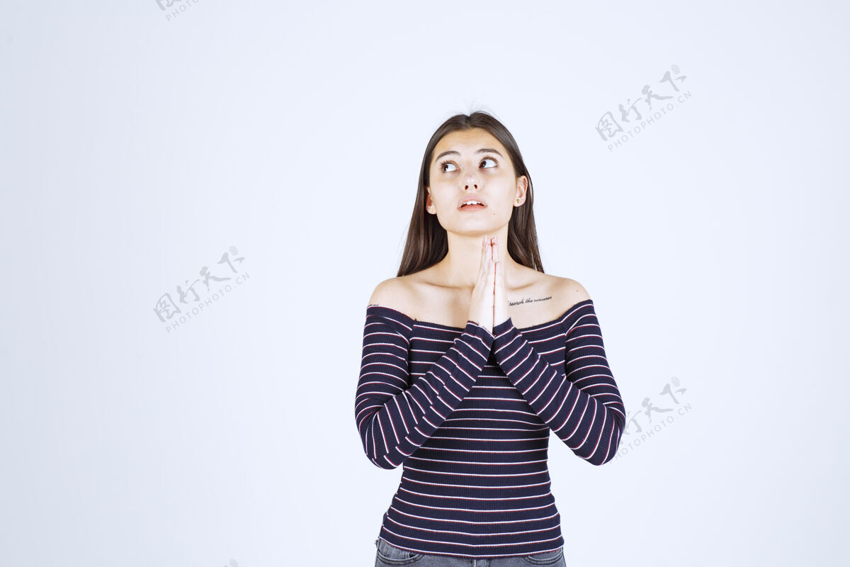 询问穿条纹衬衫的女孩双手合十祈祷年轻人类姿势