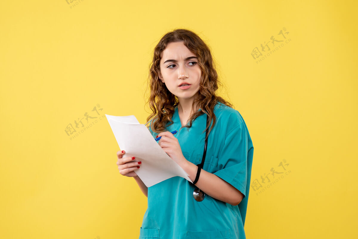 女人正面图女医生穿着医用衬衫手持分析 制服covid-19健康情绪大流行漂亮黄色文件