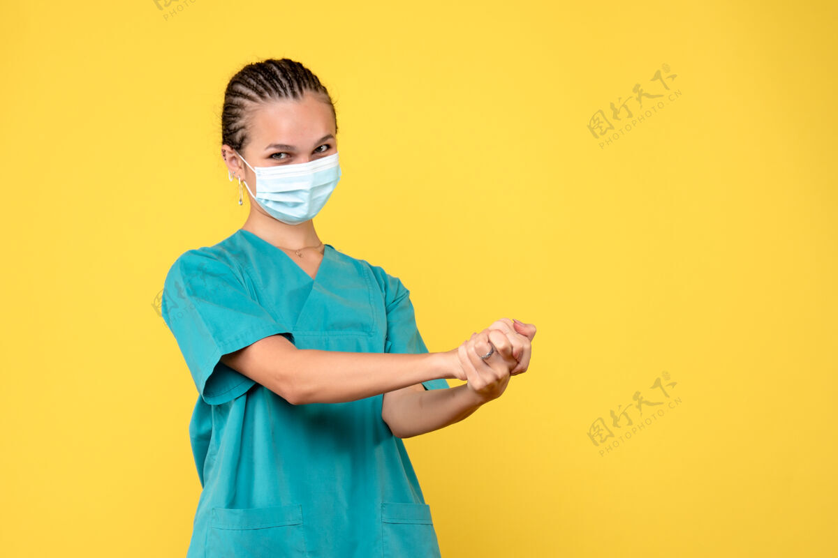 护士正面图黄色桌子上穿着医用衬衫和口罩的女医生大流行性健康covid-19医院护士病毒健康专业人物