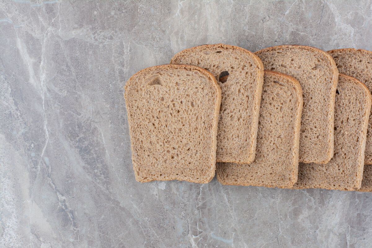 烘焙在大理石表面放几片棕色面包切片谷物健康