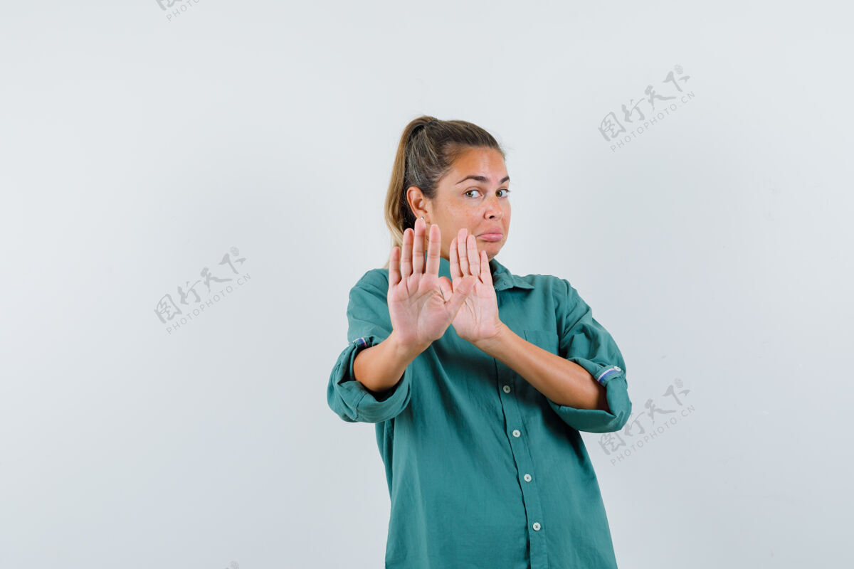 女人一位身穿绿色上衣的年轻女士双手举着停车标志 看上去很可爱女性衬衫干净